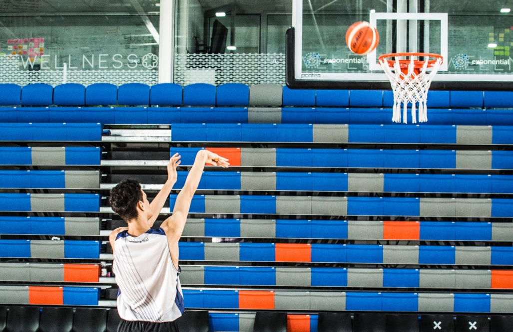 niño lanzando una pelota al aro de basquet